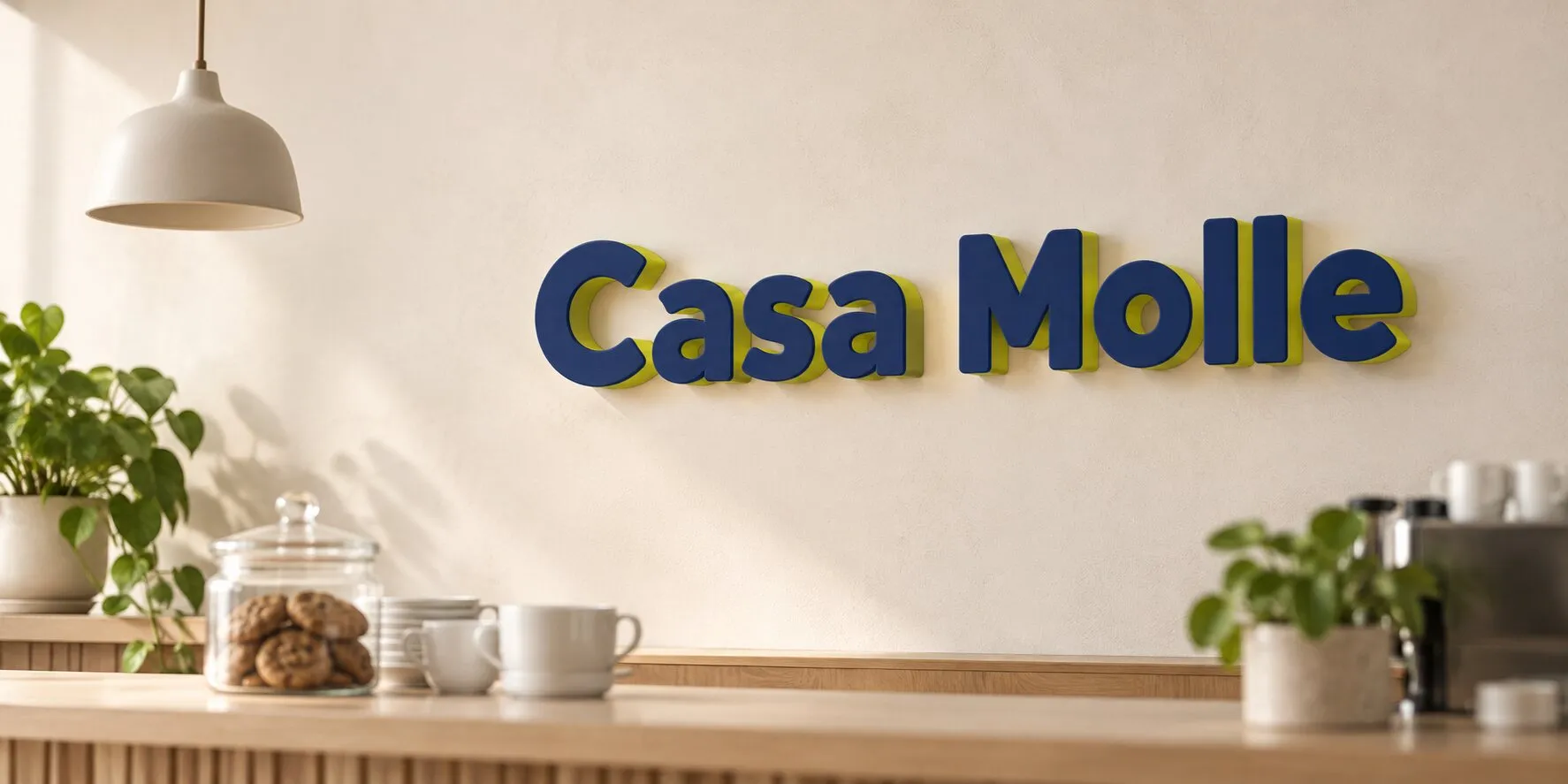 La pared de un café con el letrero Casa Molle en letras azul marino con cantos lima, sobre un mostrador con tazas, un frasco de galletas y plantas.